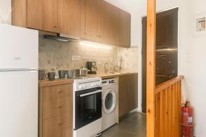 a kitchen with a white stove and a refrigerator at Skordalos Maisonette - Crete Cozy & Bright Nest in Áno Viánnos