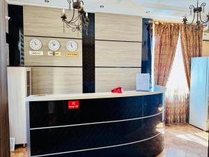 a reception desk with clocks on the wall at Hotel VANGOGH in Zhezdi