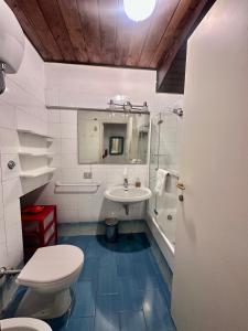 a bathroom with a toilet and a sink and a tub at Casa Oliva Ansedonia in Ansedónia