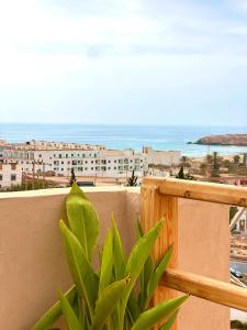 a view of the ocean from a balcony with a plant at Balance Surf Morocco , Quality rooms , Moroccan food , Activities in Aourir +77 photos