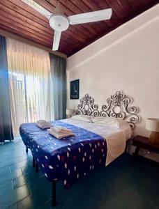 a bedroom with a large bed with a blue blanket at Casa Oliva Ansedonia in Ansedónia