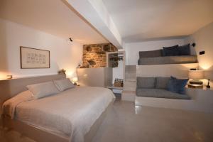a bedroom with a bed and a couch and stairs at Vivian Suites Katoi in Triandáros