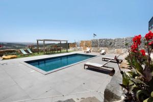 a swimming pool in a yard with a stone wall at Peace House Lourinhã in Lourinhã