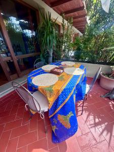 a table with a blue table cloth on a patio at Casa Oliva Ansedonia in Ansedónia +10 photos