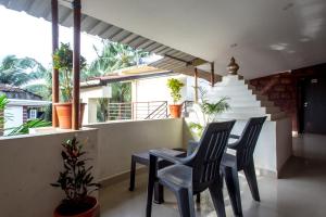 d'une table et de chaises sur un balcon orné de plantes. dans l'établissement Kartik Resort, à Mandrem