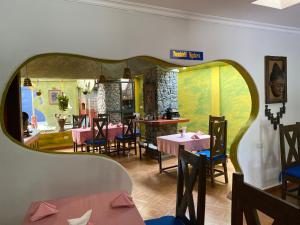 a restaurant with tables and chairs and a large mirror at parachichi house Bed and Breakfast in Arusha