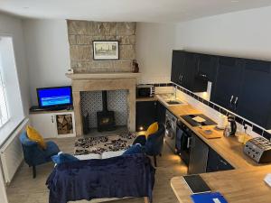 a kitchen with a fireplace and a table and chairs at Mulberry Court At Hollins Mount - 174 Hollins Rd in Walsden