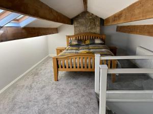 a bedroom with a wooden bed in a attic at Mulberry Court At Hollins Mount - 174 Hollins Rd in Walsden