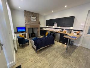 a kitchen with a living room with a fireplace at Mulberry Court At Hollins Mount - 174 Hollins Rd in Walsden