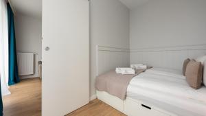 1 dormitorio blanco con 1 cama con paredes blancas en Flatbook Apartamenty - Sztutowo Perła Mierzei II, en Sztutowo