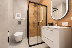 Un baño con ducha, inodoro y lavabo. en Flatbook Apartamenty - Sztutowo Perła Mierzei II, en Sztutowo 12 fotos más