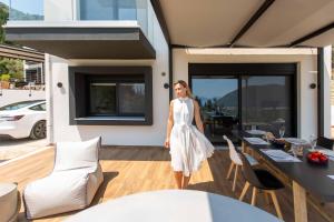 a woman in a white dress is standing on a patio at Vasiliki Houses in Vasiliki
