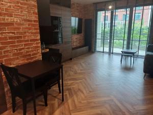 - un salon avec une table et un mur en briques dans l'établissement Apartament Loft & glow Montownia, à Gdańsk