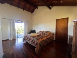 a bedroom with a bed and a large window at Casa com Hidro e Ozônio próximo ao Centro de Alto in Alto Paraíso de Goiás