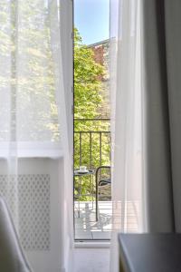 ein Fenster mit Blick auf einen Balkon mit einem Stuhl in der Unterkunft Ekaterina II Hotel in Odessa + 37 Fotos