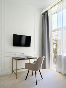 ein weißes Zimmer mit einem Schreibtisch und einem Stuhl in der Unterkunft Ekaterina II Hotel in Odessa
