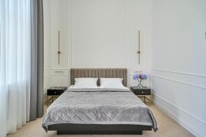 um quarto com uma cama grande com duas mesas e duas janelas em Ekaterina II Hotel em Odessa mais 37 fotografias