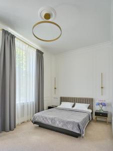 ein Schlafzimmer mit einem Bett und einem großen Fenster in der Unterkunft Ekaterina II Hotel in Odessa