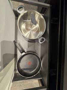 リヴィウにあるАпартаменти на Площі Ринокの2つの鍋とストレーナーを備えたキッチン