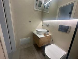 a bathroom with a white sink and a toilet at Perlia Cozy Apartment in Poros +36 photos