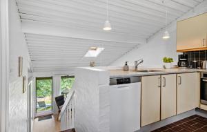 una cocina abierta con armarios blancos y una escalera en 2 Bedroom Stunning Home In Allinge, en Allinge 14 fotos más