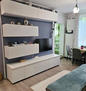 a living room with a large white entertainment center at Apartament Zarnesti free parking VMP 2 in Zărneşti