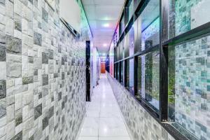 a hallway of a building with tile walls and windows at Hotel O MIZPAH INN in Chennai