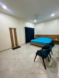 Habitación con cama y silla. en ClubGreens, en Jorhat