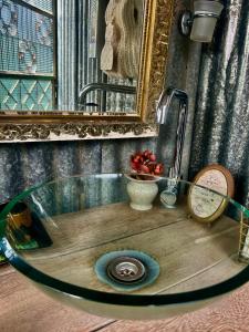 a bathroom with a sink with a clock and a mirror at Green Bus unique & private 3 min from Coral Bay in Akoursos