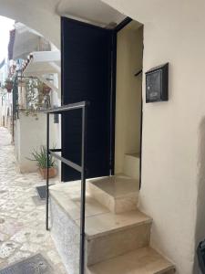a set of stairs with a black door on a building at Dimore Levante - La Dimora nel borgo in Turi