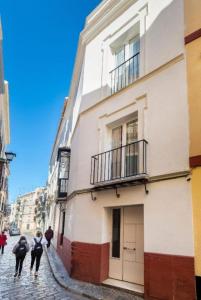 a group of people walking down a street next to a building at Bajo Gerona in Seville