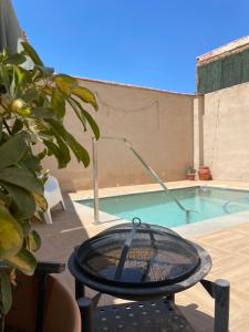 a tennis racket on a table next to a swimming pool at La Casa De Los Gatetes in Dúrcal