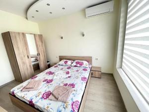 a bedroom with a bed with flowers on it at 2BR Garden Bay Apartment in Varna City