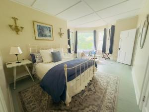 a bedroom with a bed with a blue comforter at Franklin Manor Bed and Breakfast in Saranac Lake