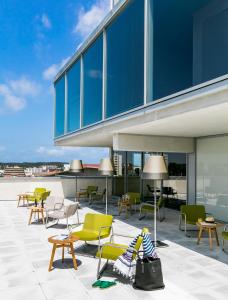 eine Terrasse mit Stühlen und Tischen auf einem Gebäude in der Unterkunft Okko Hotels Bayonne Centre in Bayonne