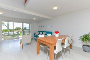 Un comedor con una mesa de madera y sillas blancas. en Beach Side Getaway- Free WIFI, en Dunsborough