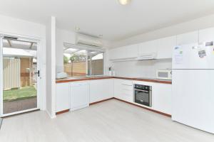 Una cocina con gabinetes blancos y un refrigerador. en Beach Side Getaway- Free WIFI, en Dunsborough 10 fotos más