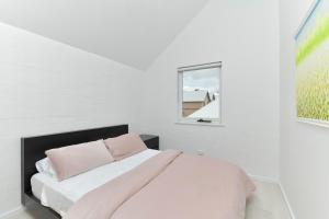 Una habitación blanca con una cama y una ventana en Beach Side Getaway- Free WIFI, en Dunsborough