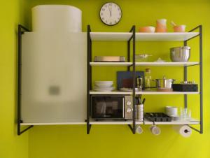 a shelf with a microwave and a clock on a green wall at La silla de San Bernardo in Avilés +4 photos