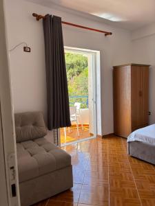 a living room with a couch and a bed at Harbour View Stay in Himare