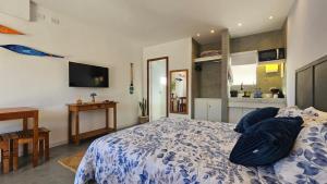 a bedroom with a bed with blue pillows on it at ensueños in Búzios