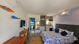 a bedroom with a bed and a table and a kitchen at ensueños in Búzios