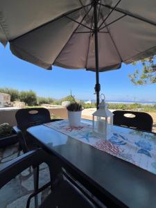 a table with an umbrella on a patio at Handra Villa in Asfendioú