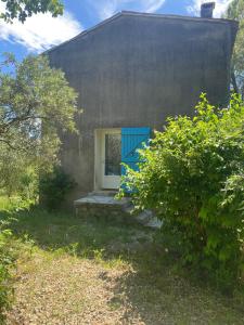 a small house with a blue door and a window at Au coeur de l'oliveraie in Draguignan