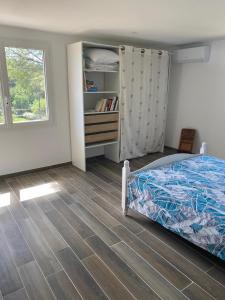 a bedroom with a bed and a wooden floor at Au coeur de l'oliveraie in Draguignan
