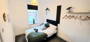 a bedroom with a bed with a cat sitting on it at Contractor-Friendly 3-BR - Sleeps 5 - Free WiFi in Barrow in Furness