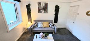 a living room with a couch and a window at Luxury 3-BR - Sleeps 5 - Fast WiFi -Parking in Barrow in Furness