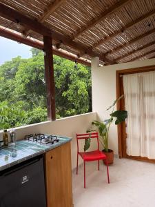 a kitchen with a stove and a red chair at Casa Colorida in Santa Marta