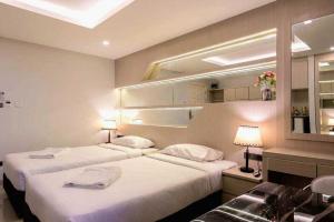 a hotel room with two beds and a sink at B-your home Hotel Don Mueang Airport Bangkok 如你家酒店 in Bangkok