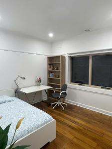 a bedroom with a bed and a desk and window at Oakleigh South Charm in Oakleigh South +10 photos